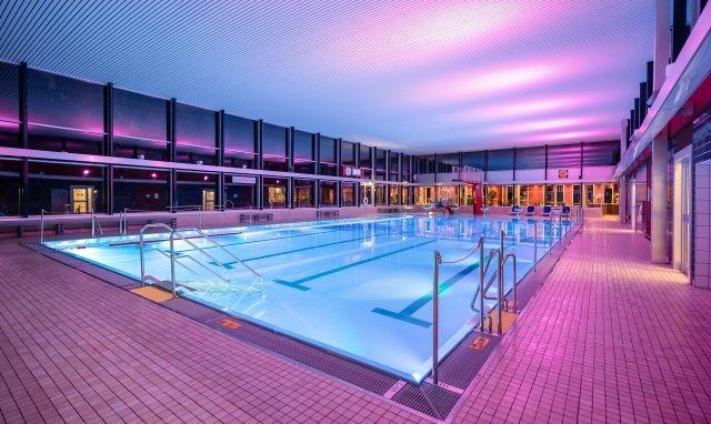 leeres Hallenbad mit lilafarbener Beleuchtung